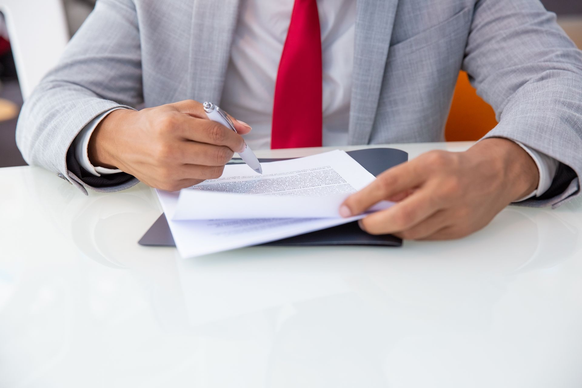 An image showing a close-up of a stack of legal documents with a person's hands placing a stamp or a signature on the top page, symbolizing finalization and security.